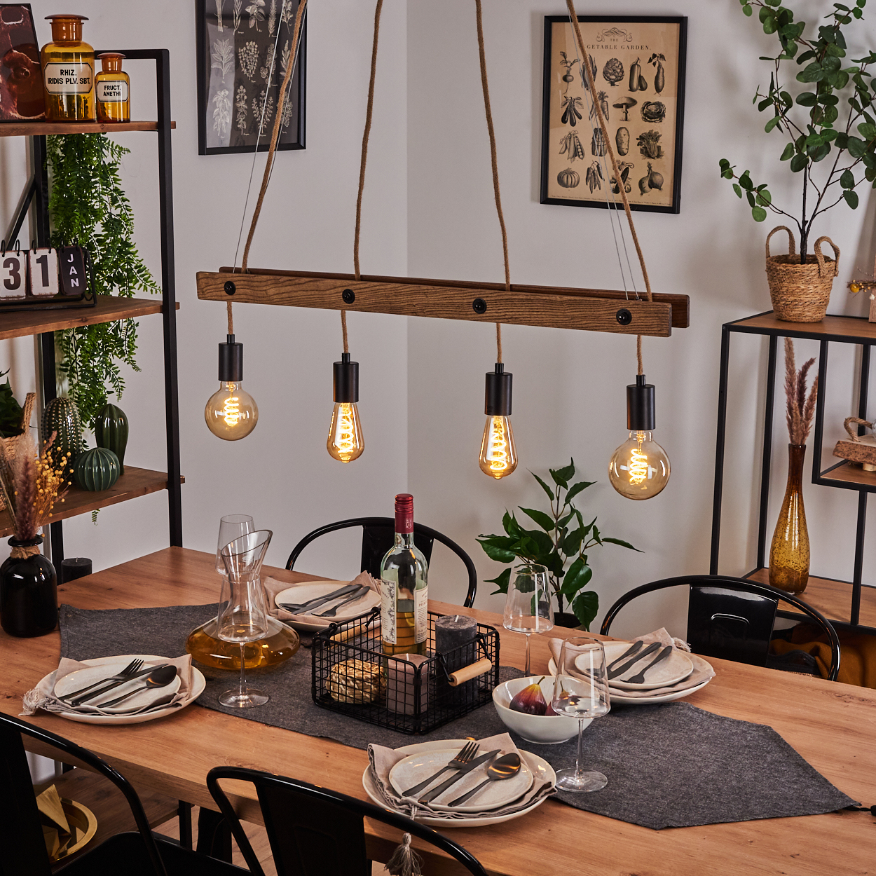 Ein Holzbalken mit vier Lampen über einem Holztisch mit gedeckter Tafel.