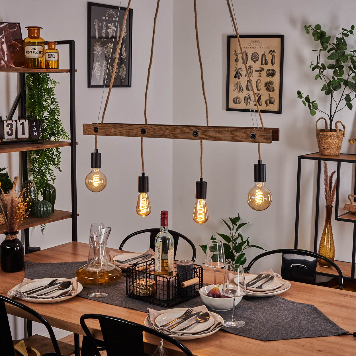 Holztisch mit gedeckter Tafel, Hängelampen und Regalen im Hintergrund.