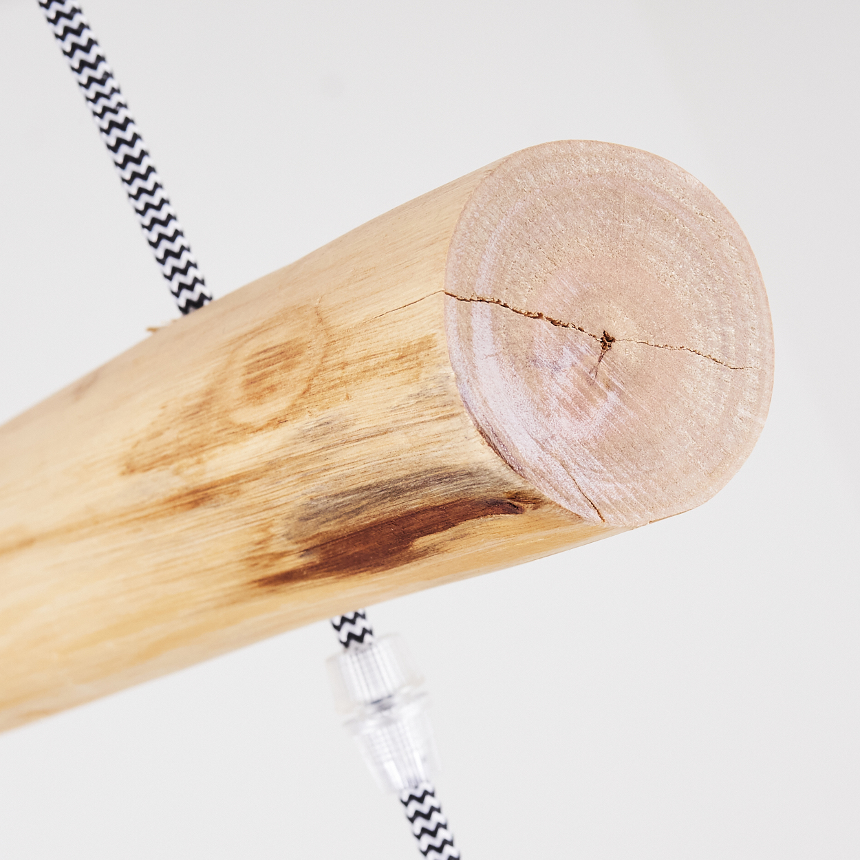 Ein naturbelassener Holzstamm mit einem schwarz-weißen Kabel, das daran befestigt ist.