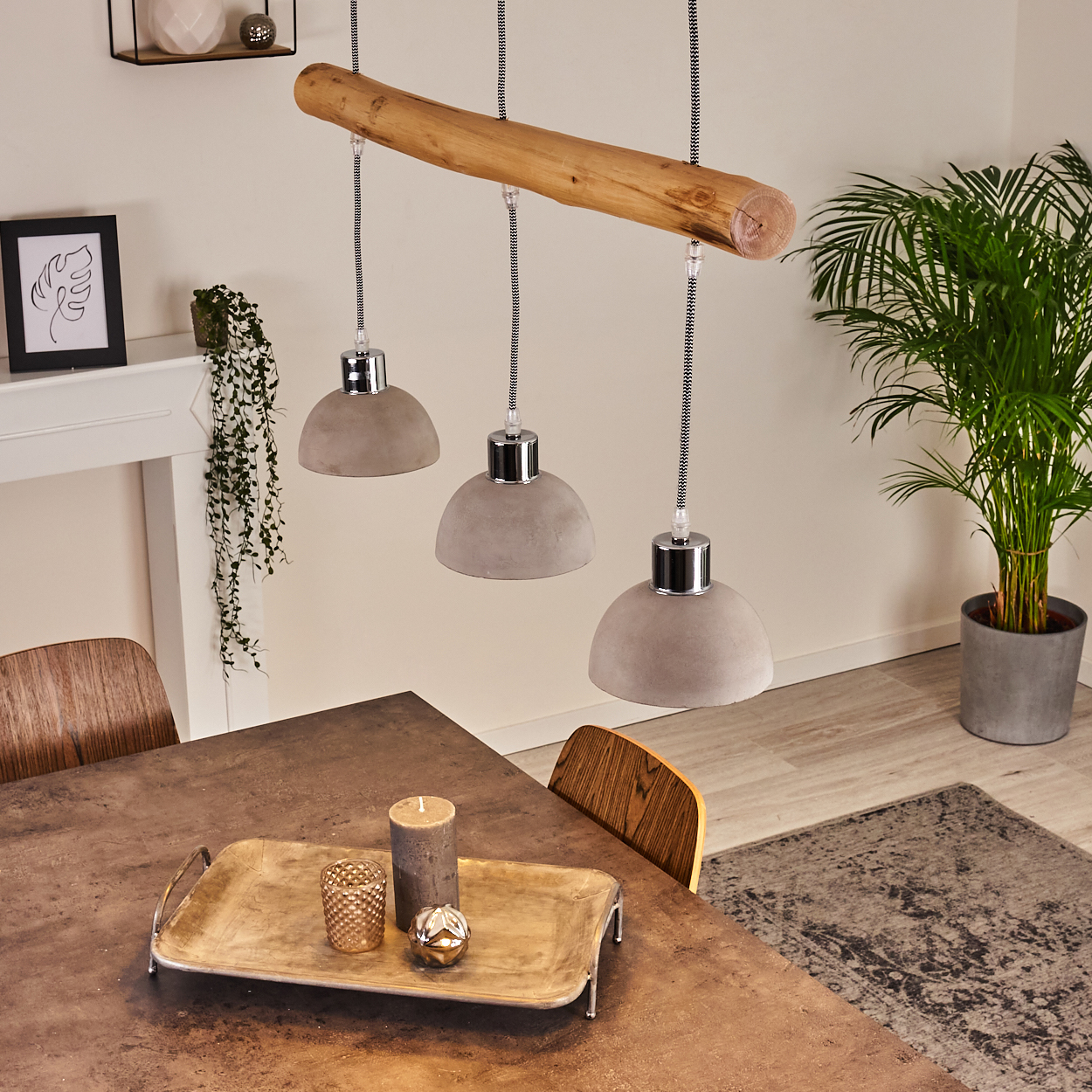 Hängelampe mit Holzstamm und drei grauen Schirmen über einem Tisch mit Deko.