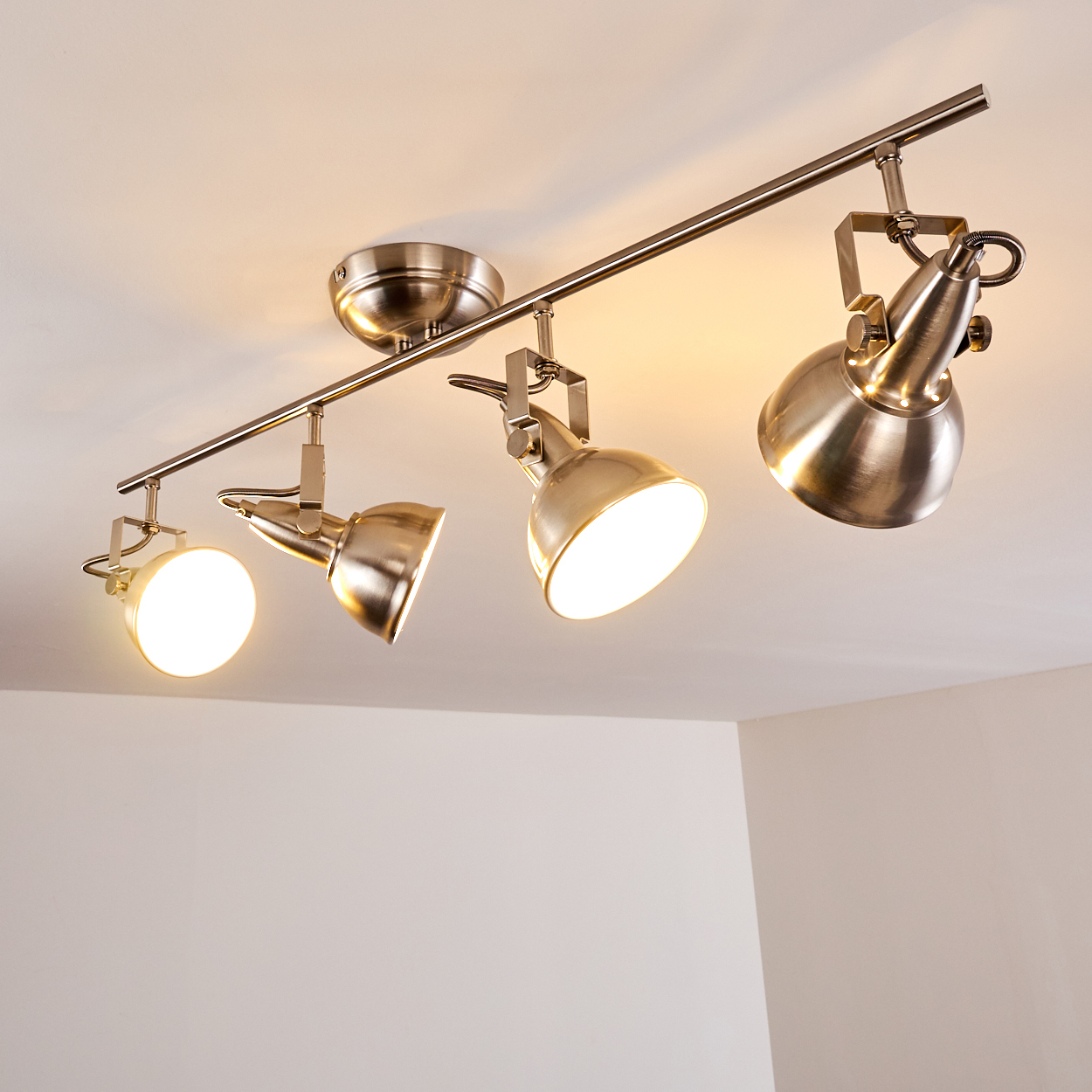 Deckenleuchte mit vier verstellbaren Spots aus gebürstetem Metall.