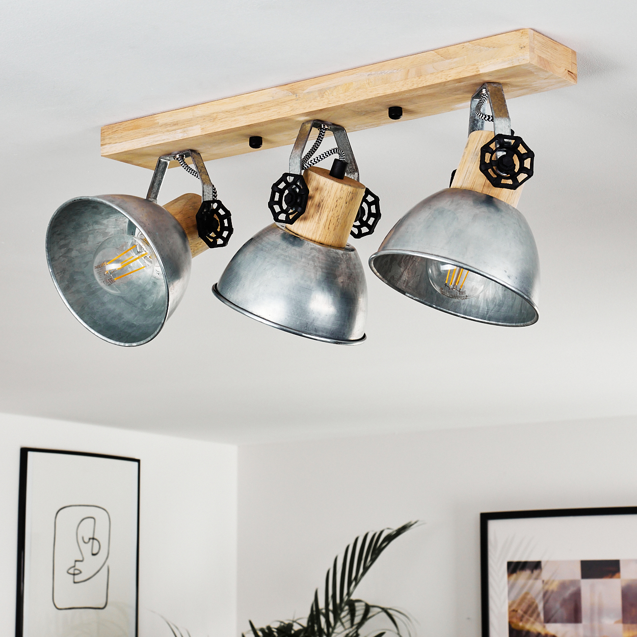 Deckenleuchte mit Holzsockel und drei verstellbaren Metallschirmen.