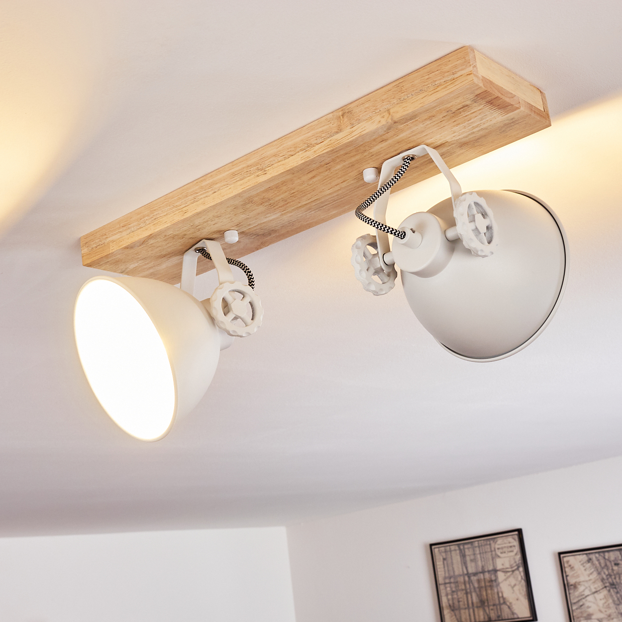 Deckenleuchte mit Holzträger und zwei weißen Strahlern, schwarz-weiße Kabel.