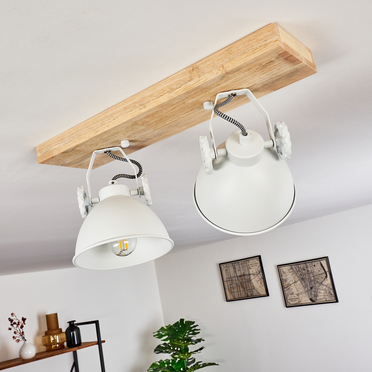 Zwei weiße Lampen hängen an einem Holzbalken von der Decke.