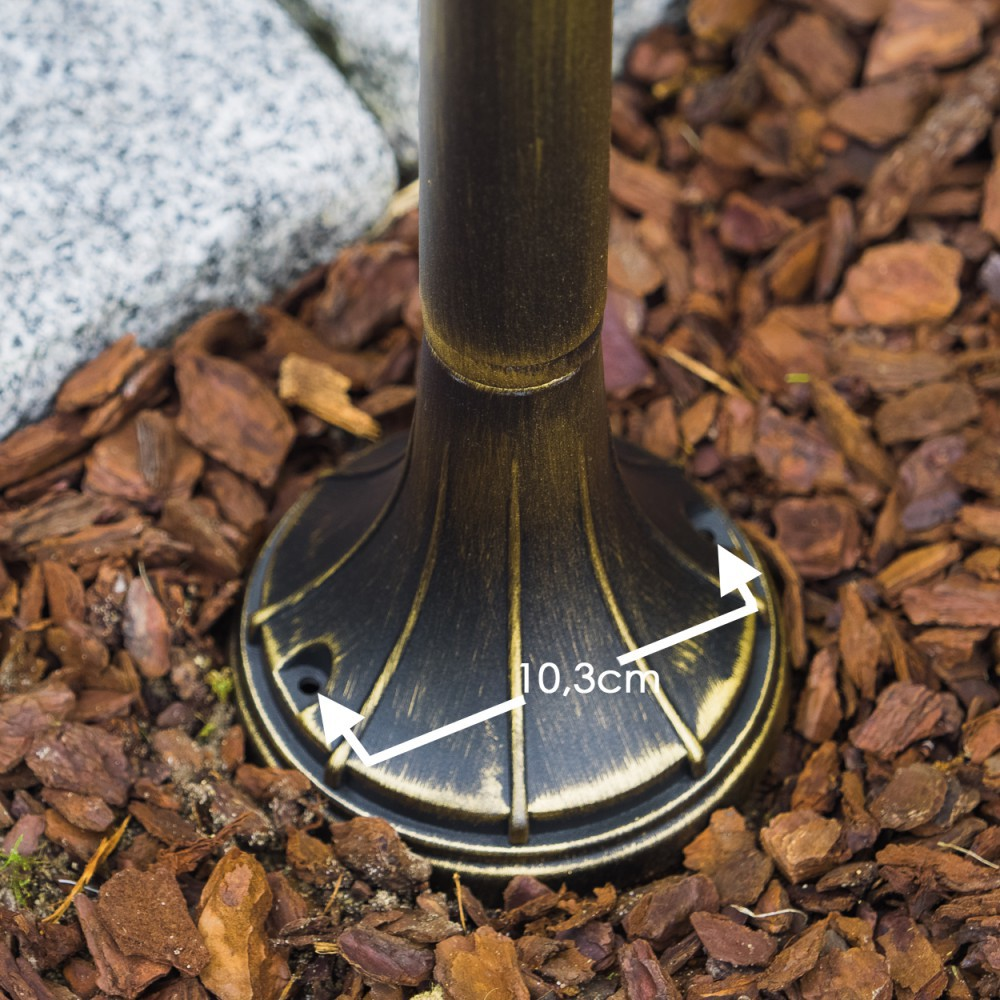 Bronzefarbener Sockel eines Pfostens misst 10,3 cm auf Rindenmulch.