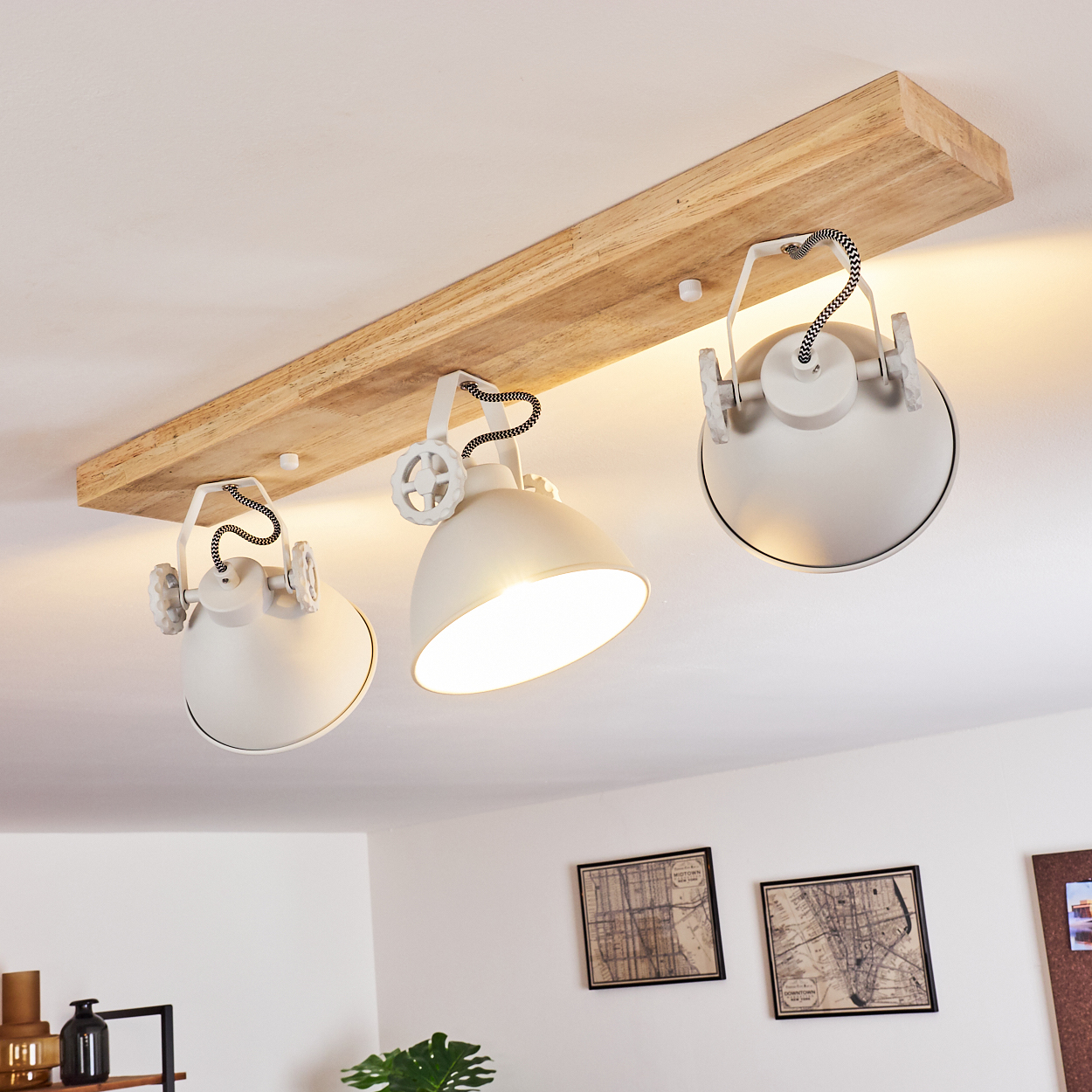 Deckenleuchte mit Holzträger und drei weißen Lampenschirmen.