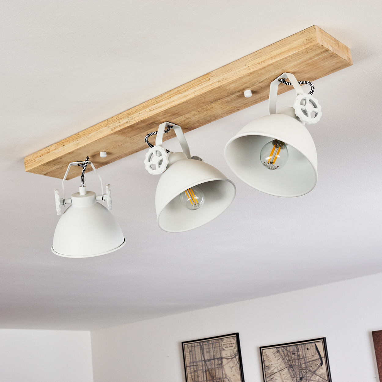 Deckenleuchte mit drei weißen Schirmen auf Holzbrettmontage.