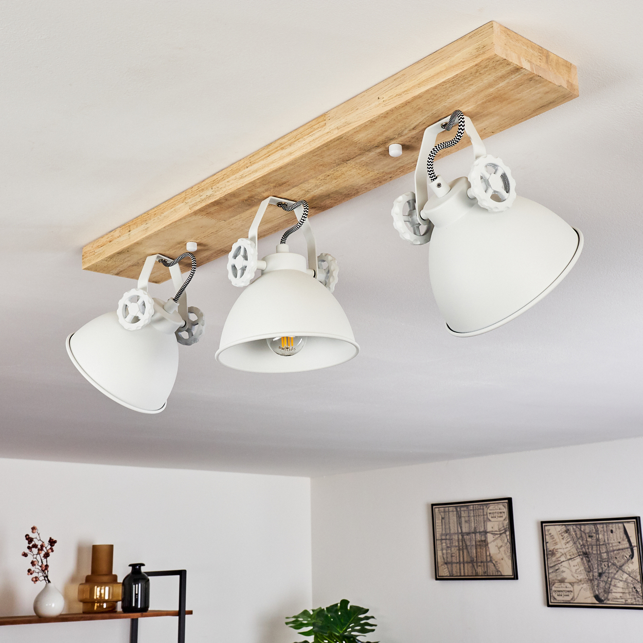 Weiße Deckenleuchte mit drei Lampenschirmen an einem Holzbrett.