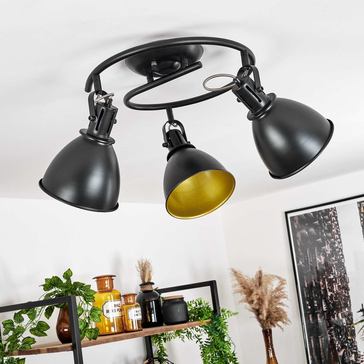 Schwarze Deckenleuchte mit drei verstellbaren Spots und goldener Innenseite.