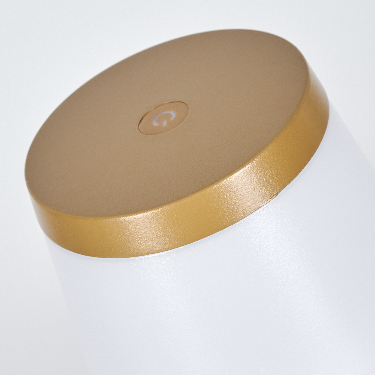 Ein weißer Zylinder mit goldener Oberseite und einem Power-Symbol.