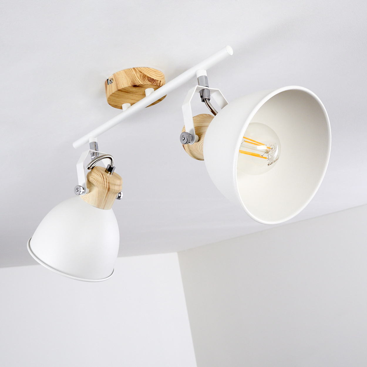 Zwei weiße Lampenschirme mit Holzdetails an einer weißen Deckenleuchte.
