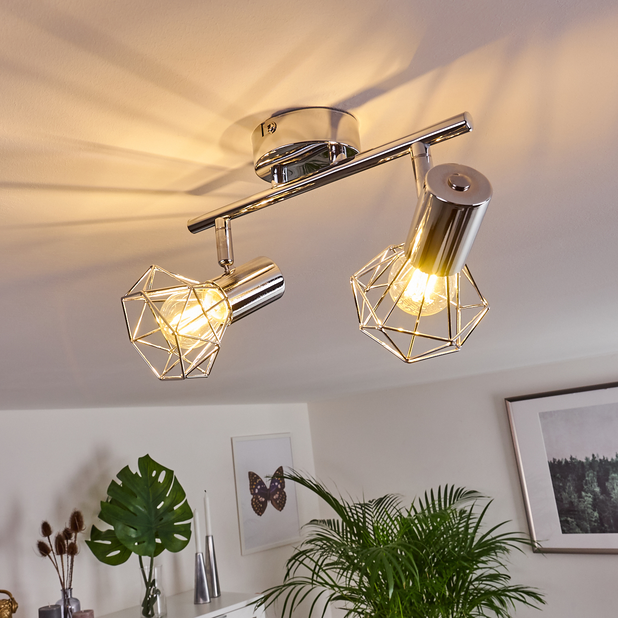 Eine moderne Deckenleuchte mit zwei verstellbaren Spots und geometrischen Metallkäfigen.