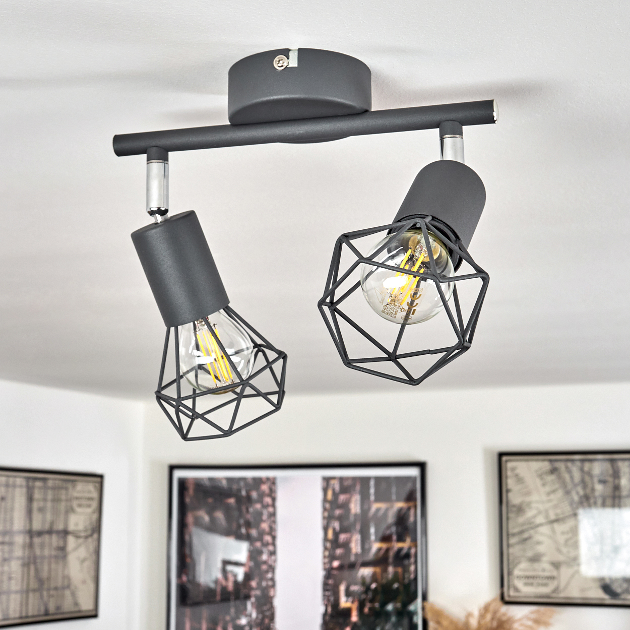 Schwarzer Deckenstrahler mit zwei Lampen und geometrischen Käfigschirmen.