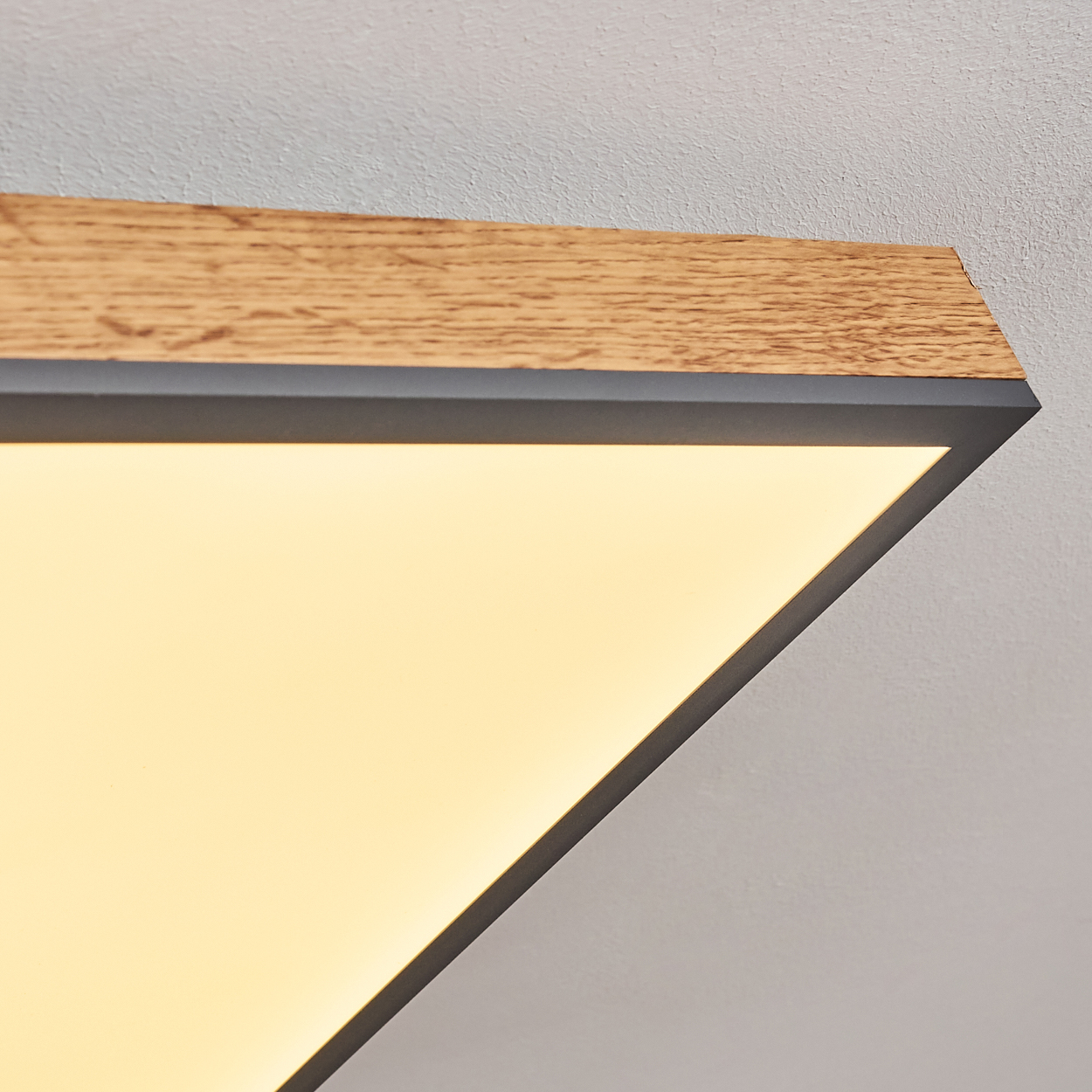 Eine Deckenleuchte mit Holz- und Metallrahmen und beleuchtetem Panel.