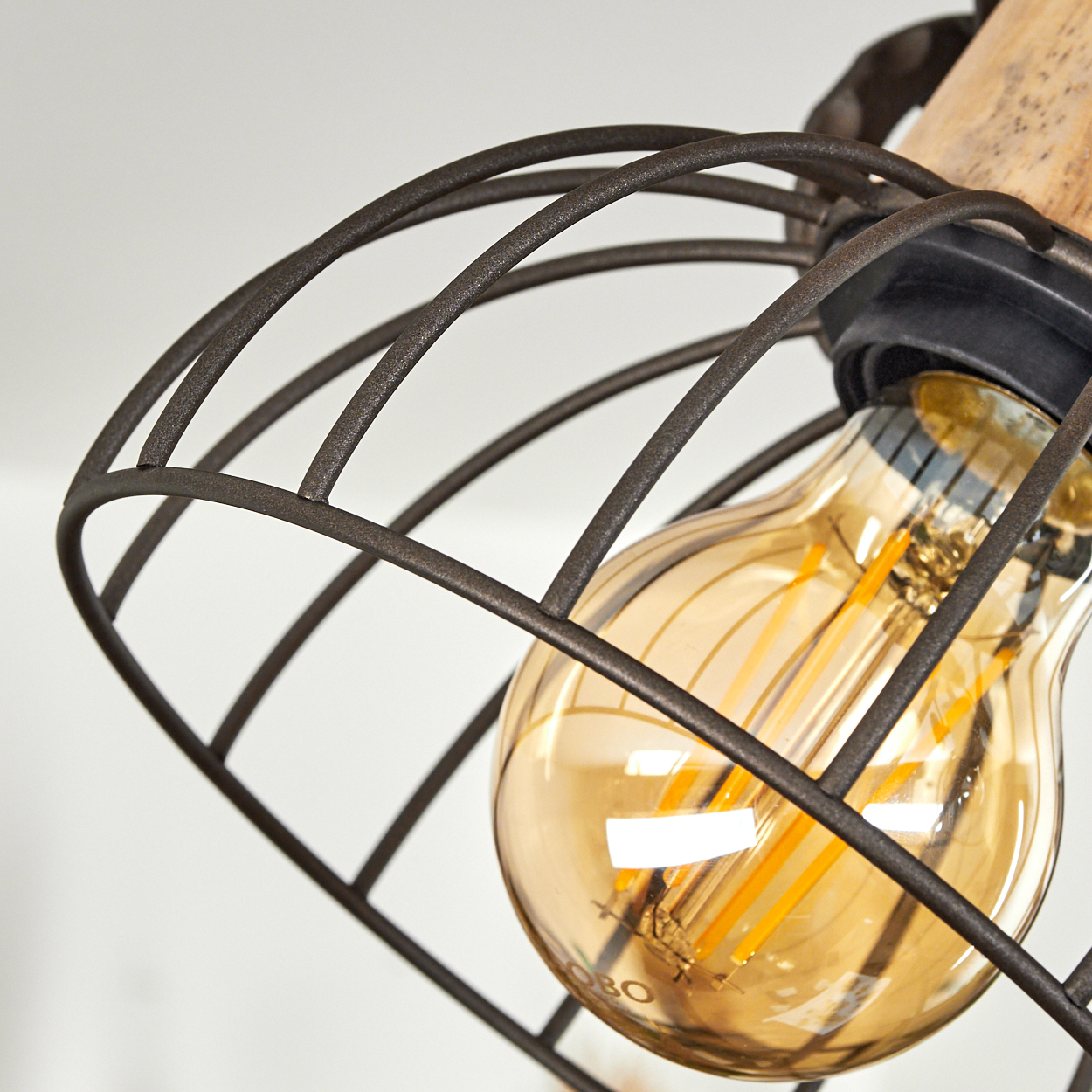 Eine Edison-Glühbirne mit einem Drahtkäfig und Holzakzenten.