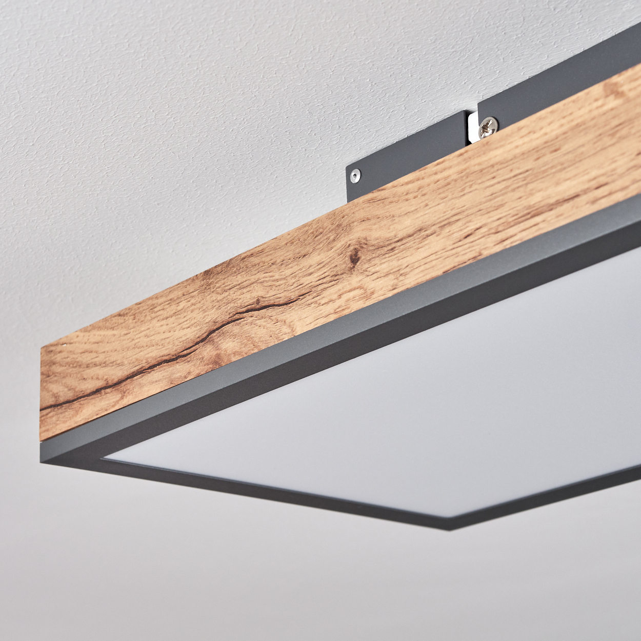 Eine Deckenleuchte mit Holzoptik und schwarzem Rahmen auf weißer Decke.