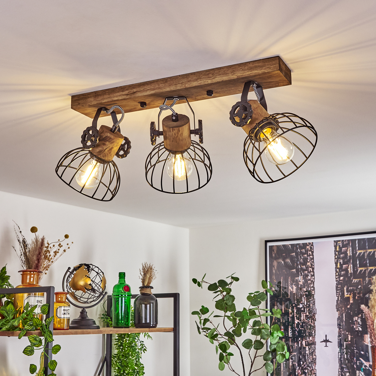 Deckenleuchte mit Holzbalken und drei Käfiglampenschirmen.