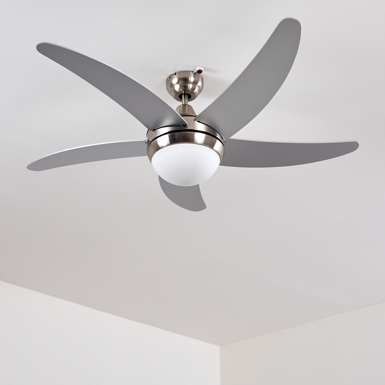 Deckenventilator mit fünf grauen Rotorblättern und einer runden Lampe.