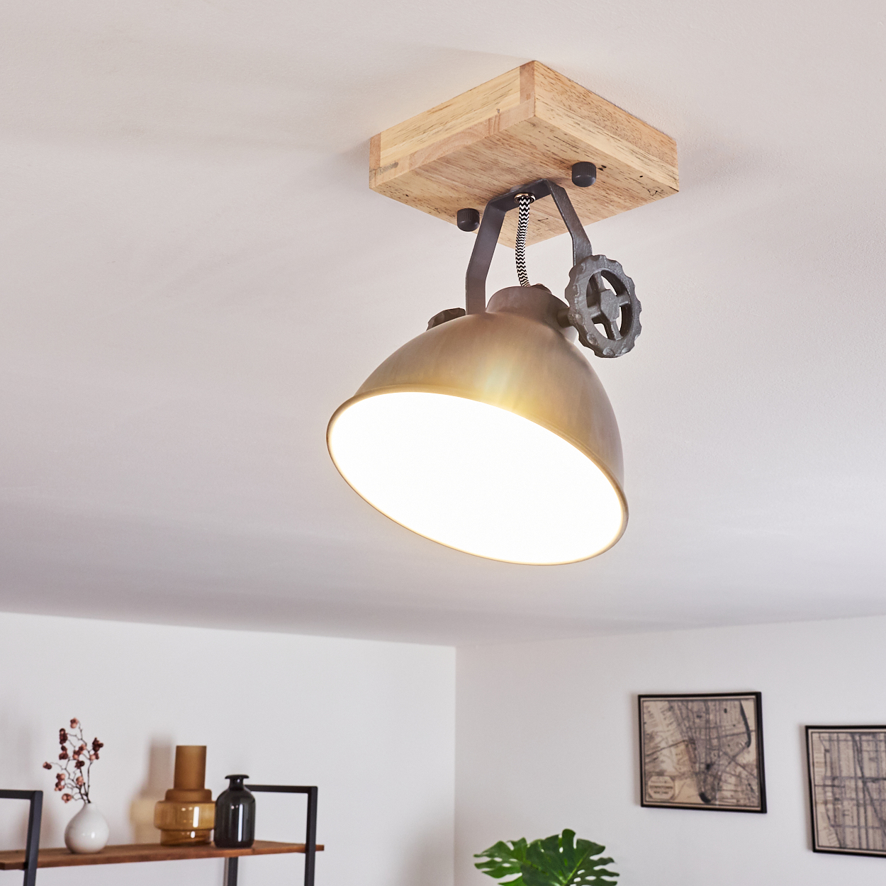 Eine Hängelampe im Industriestil mit Holzsockel und Metallschirm hängt an der Decke.