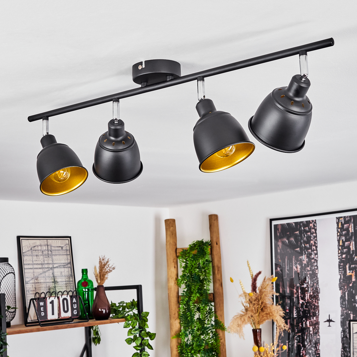 Schwarze Deckenleuchte mit vier verstellbaren Spots mit goldenem Innenleben.