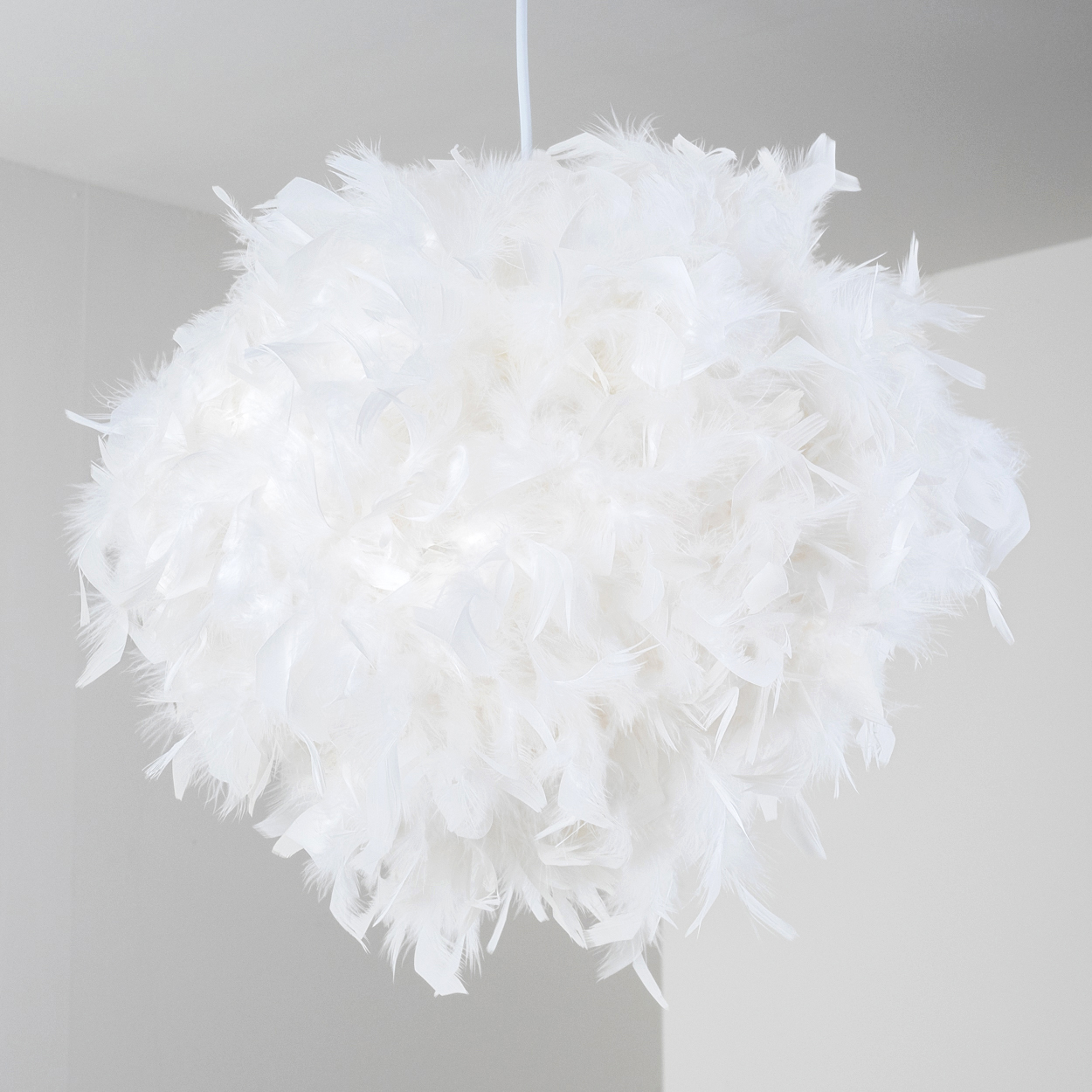 Eine weiße Federlampe hängt von der Decke, beleuchtet von innen.