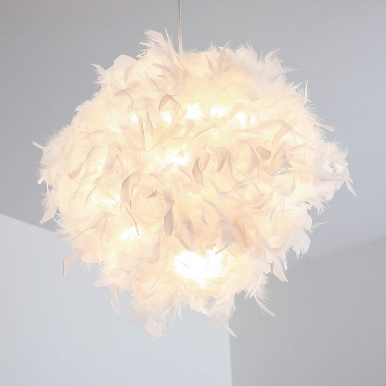 Eine weiße Federlampe hängt von der Decke.