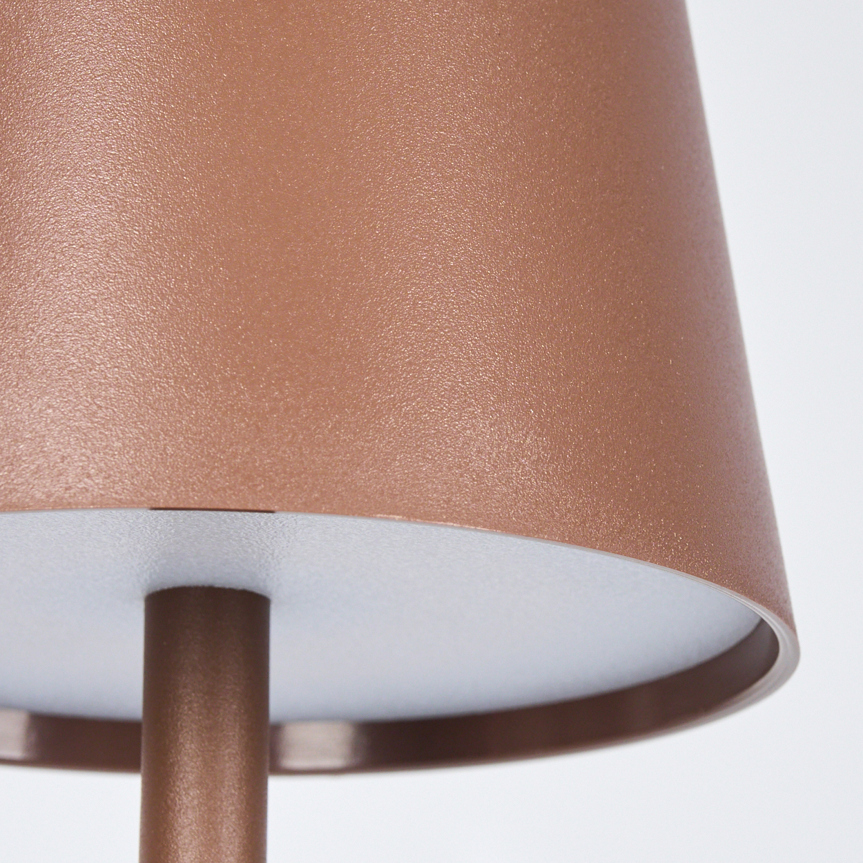 Eine Nahaufnahme eines bronzefarbenen Lampenschirms mit mattem Finish.