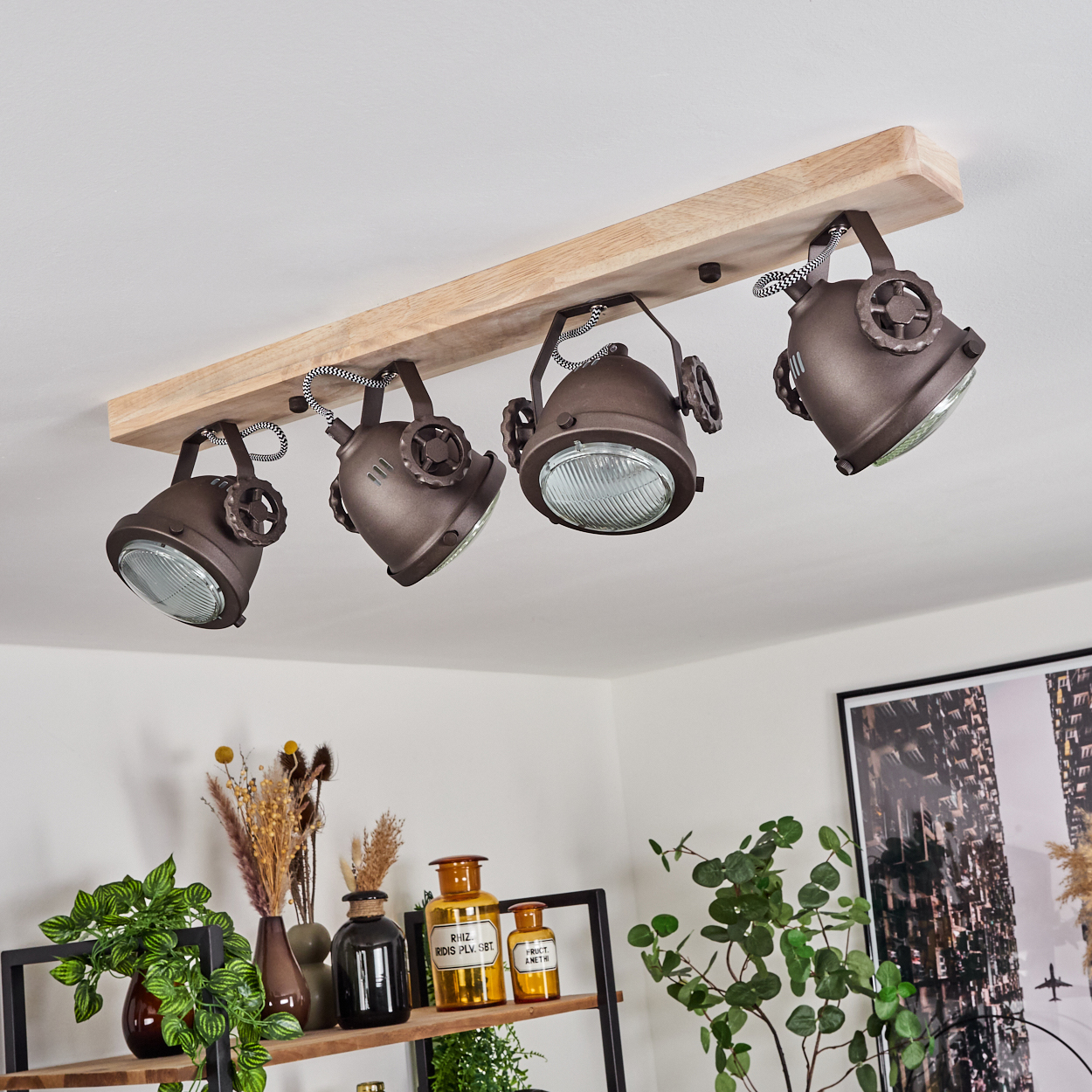 Vier braune Deckenstrahler mit Holzsockel und schwarzen Kabeln hängen an der Decke.