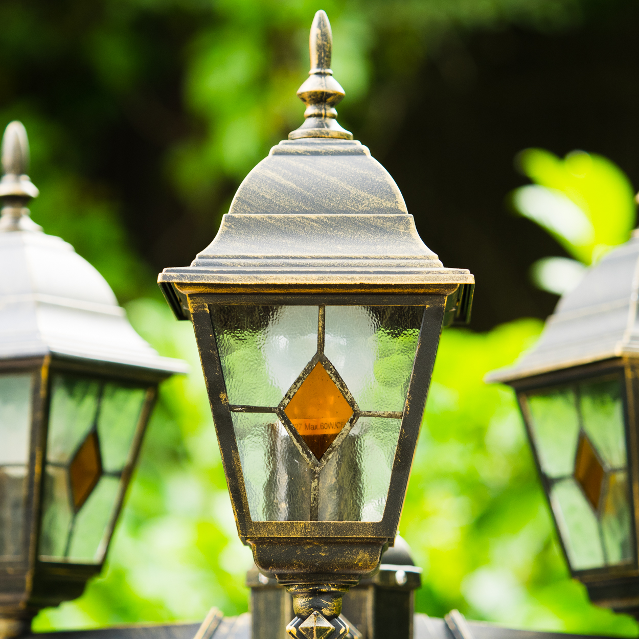 Drei dekorative Außenleuchten mit goldenen Akzenten und Glaspaneelen.