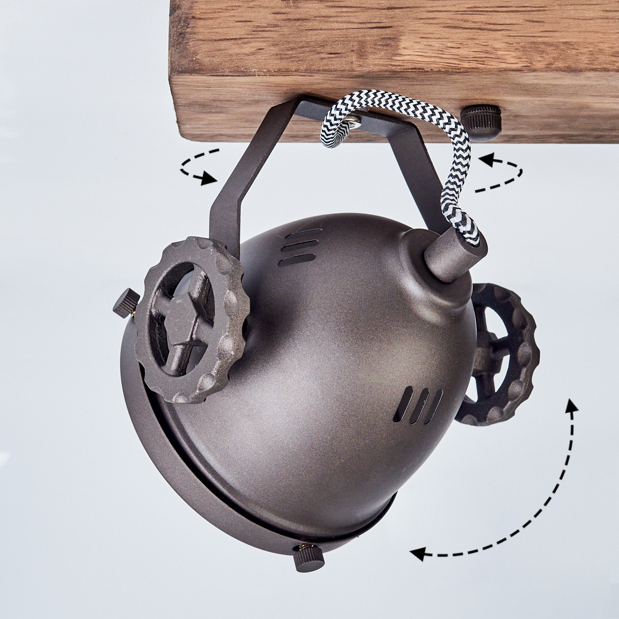 Dunkler Metallstrahler mit Zahnraddetails an Holzbalken montiert.