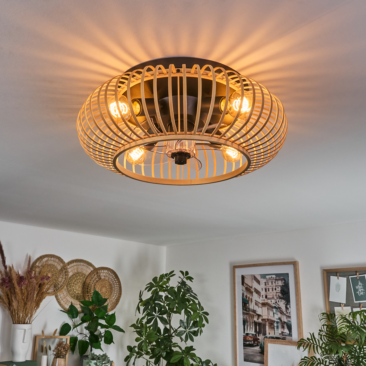 Deckenleuchte mit Holzlamellen und sichtbaren Glühbirnen wirft Lichtmuster an die Decke.