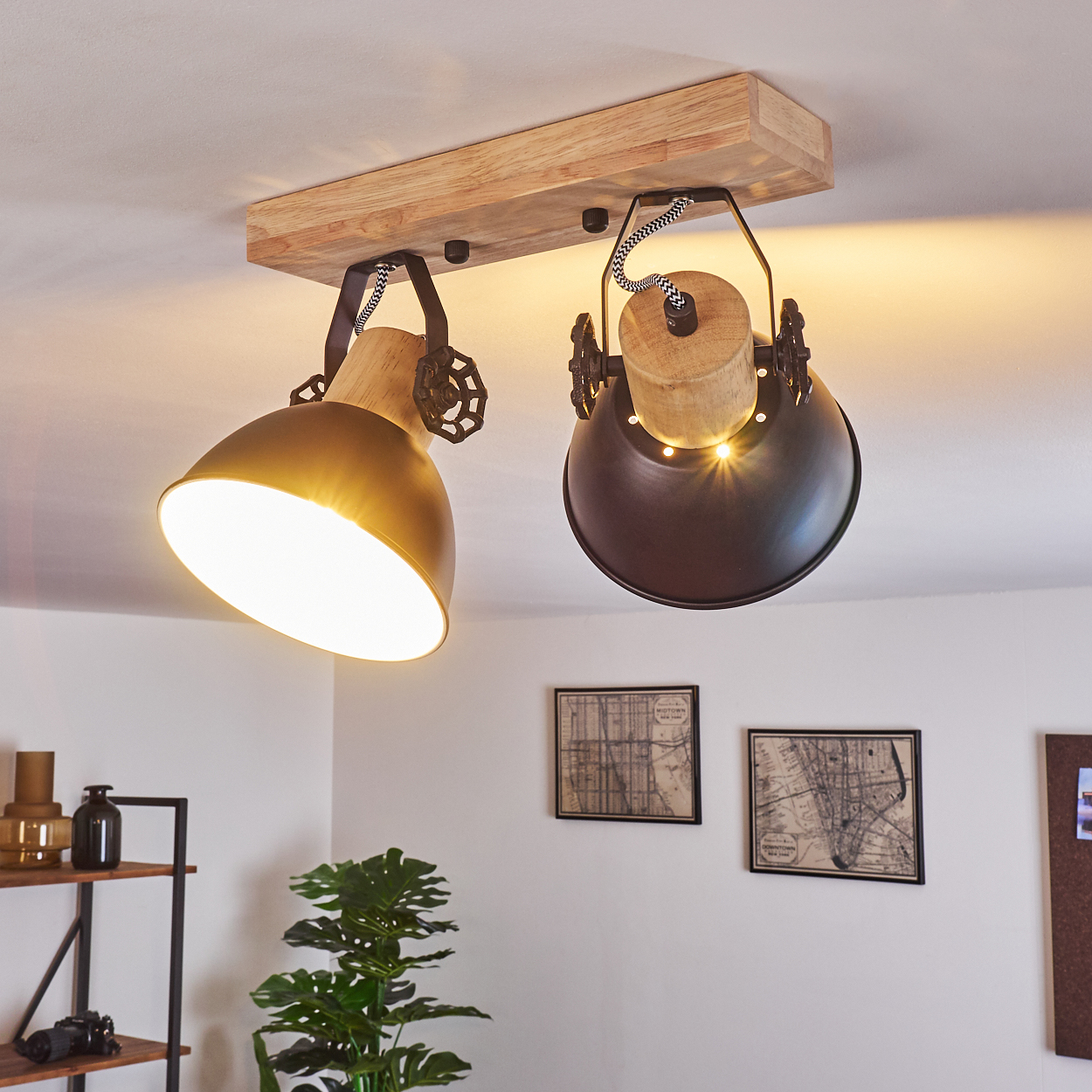 Deckenleuchte mit Holzsockel und zwei verstellbaren Lampenschirmen, eine goldfarben, eine schwarz.