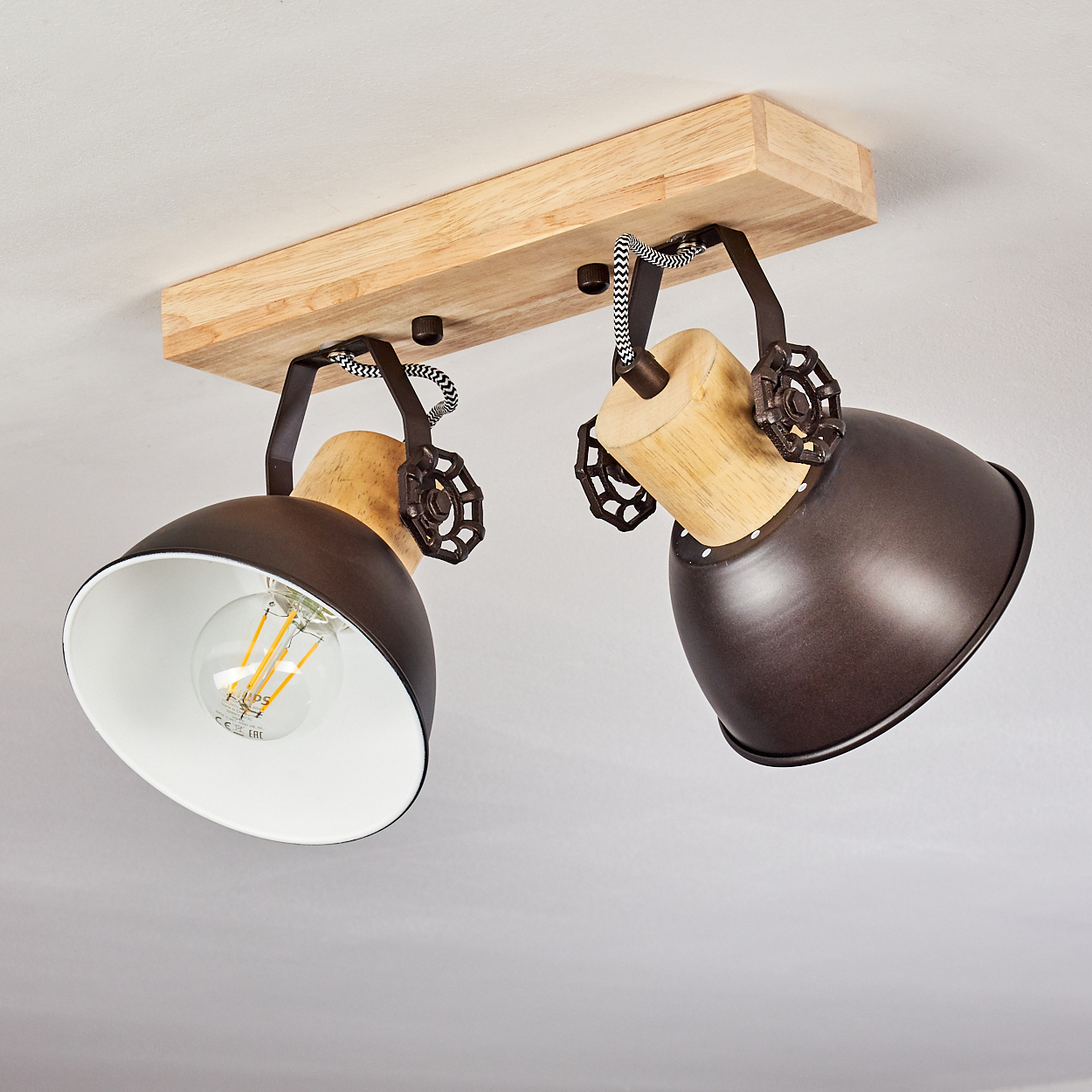 Zwei braune Lampenschirme mit Holzdetails und sichtbaren Glühbirnen an einer Holzleiste.