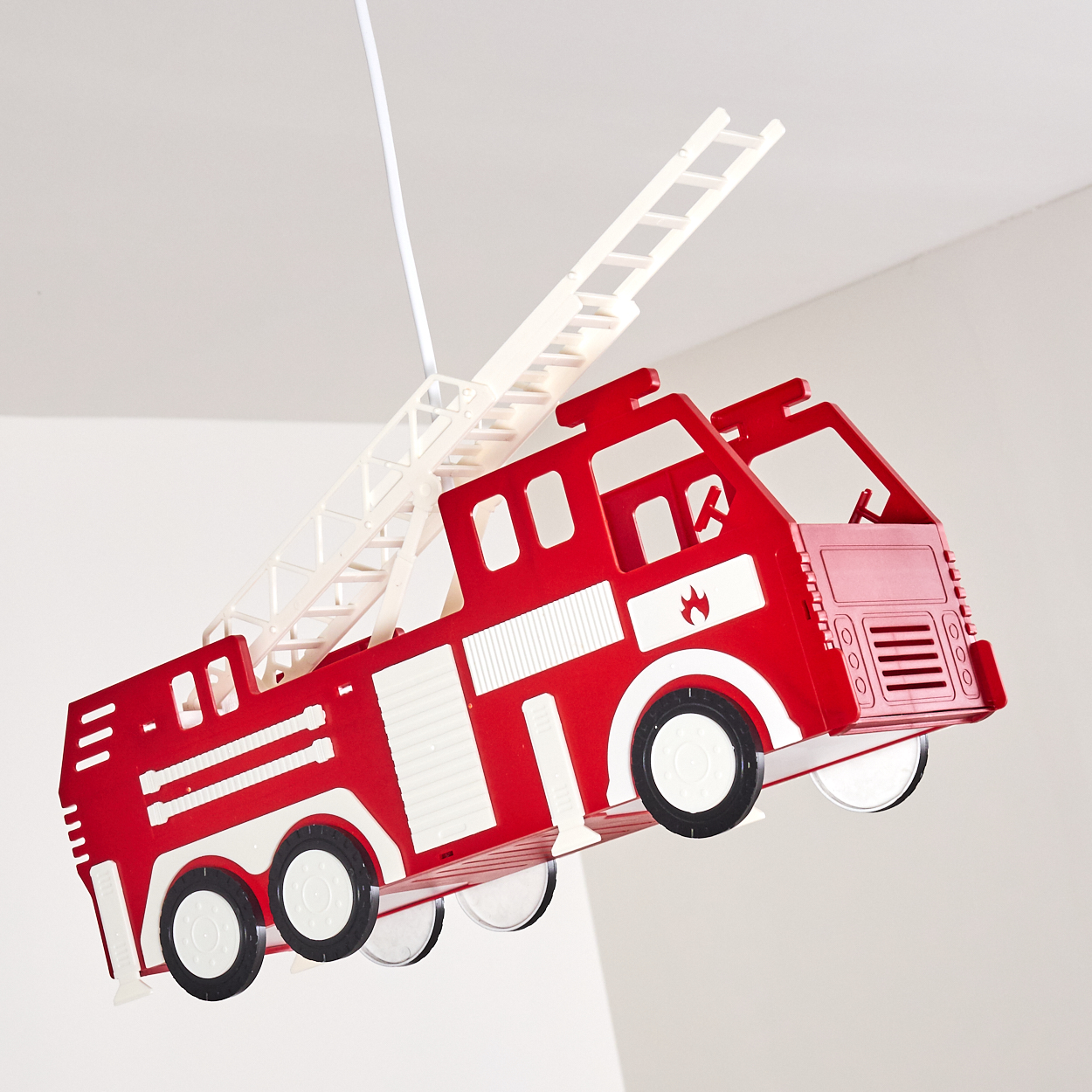 Ein rotes Spielzeug-Feuerwehrauto mit ausziehbarer Leiter hängt von der Decke.