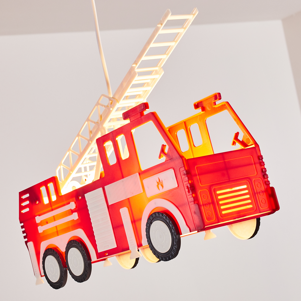 Ein rotes Feuerwehrauto-Modell mit ausfahrbarer Leiter hängt von der Decke.