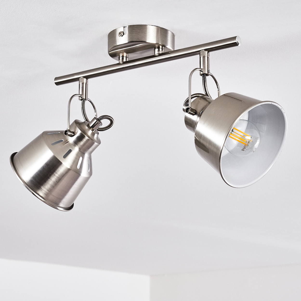 Zwei silberne Deckenstrahler mit verstellbaren Köpfen an einer Schiene.