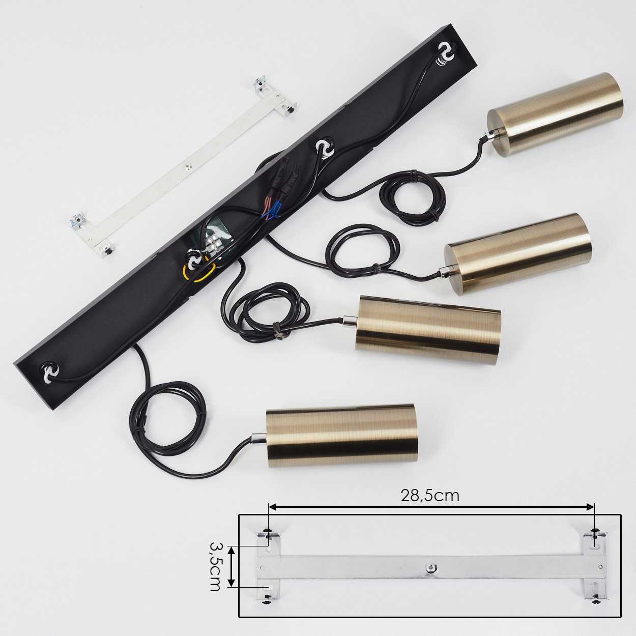 Ein schwarzer Lampenfuß mit drei bronzefarbenen Zylindern und Kabeln.