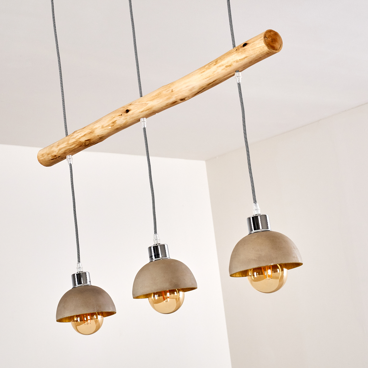 Hängelampe mit Holzstamm und drei Betonlampenschirmen.