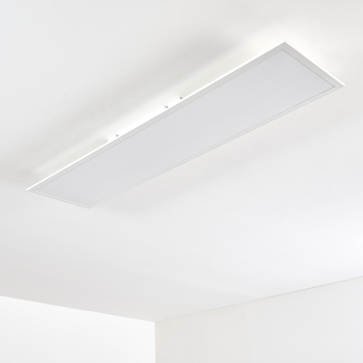 Ein rechteckiges, weißes Deckenpanel leuchtet hell an einer weißen Decke.
