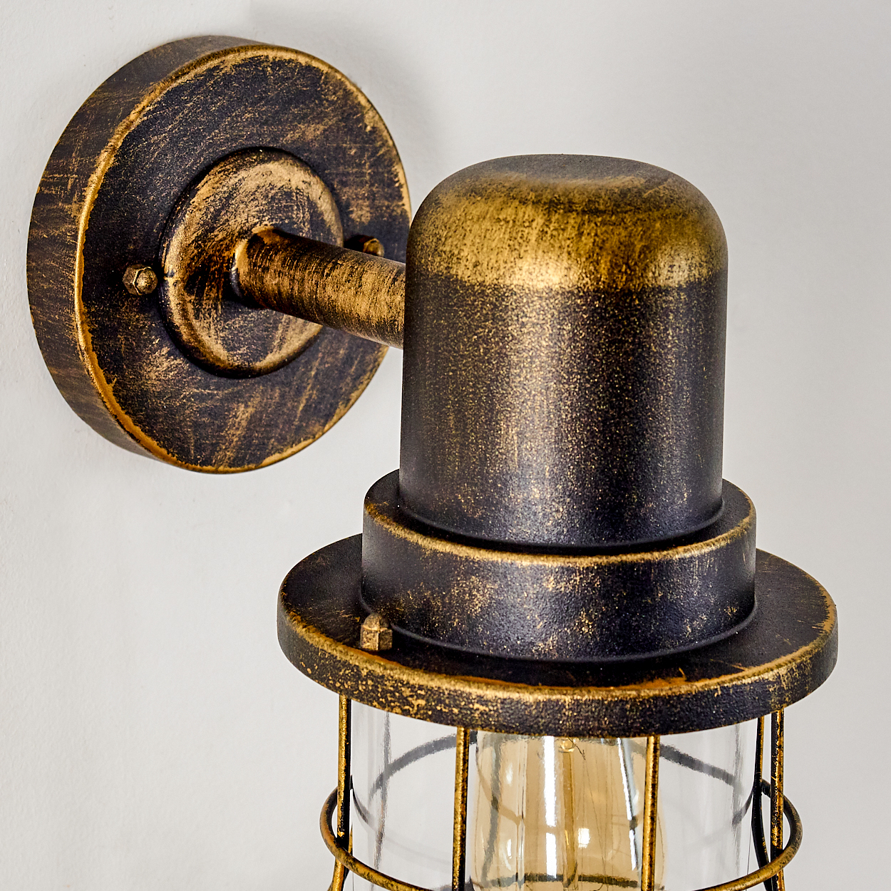 Eine Wandleuchte im Industrie-Stil mit Messing- und schwarzem Finish.