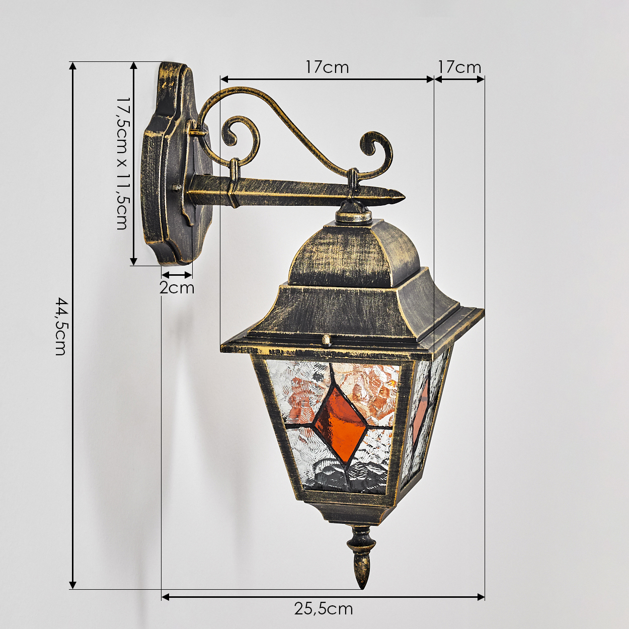 Eine antike Wandleuchte aus dunklem Metall mit Glas und Ornamen