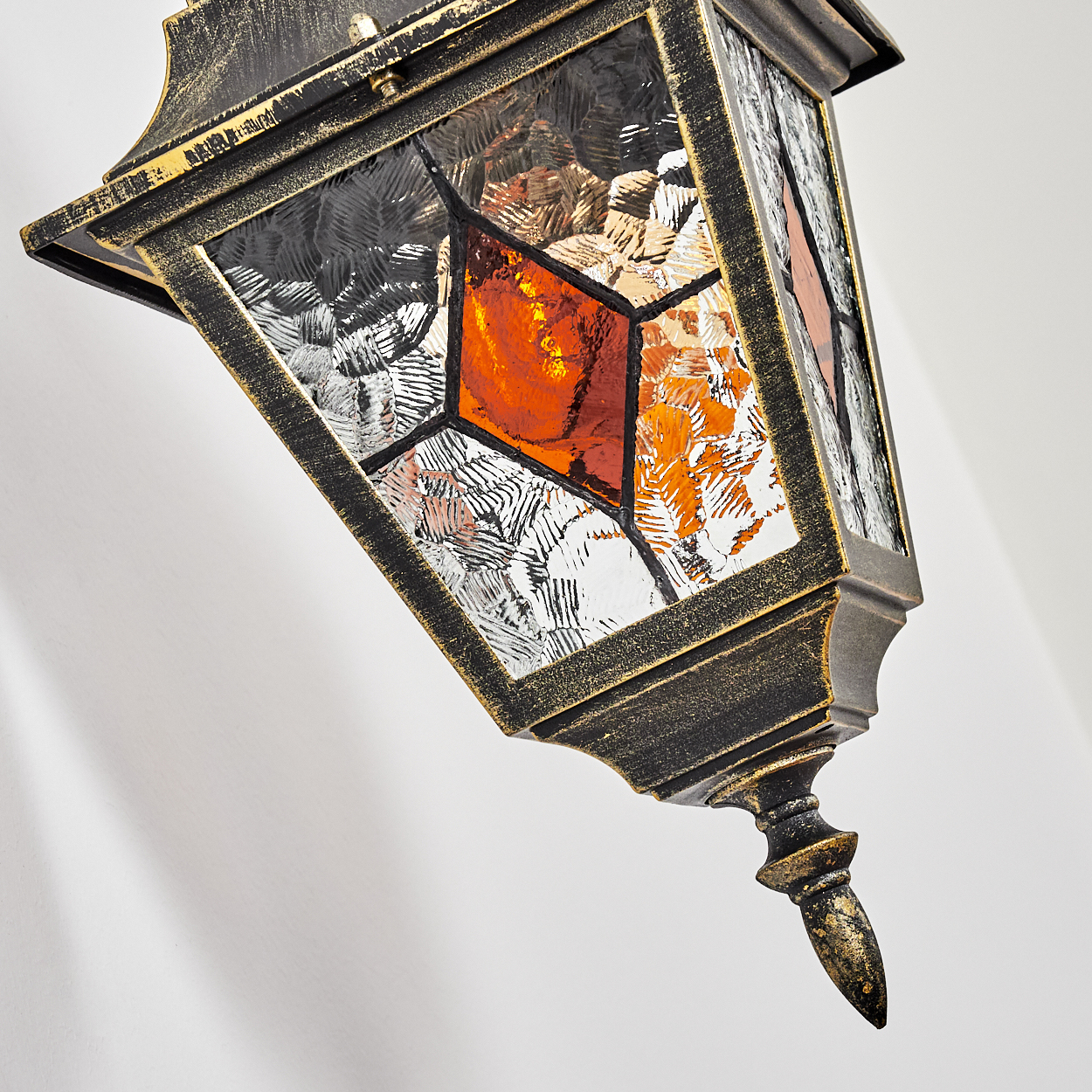 Eine antike Lampe mit Glasfenstern in Orange und Weiß, im Detail.