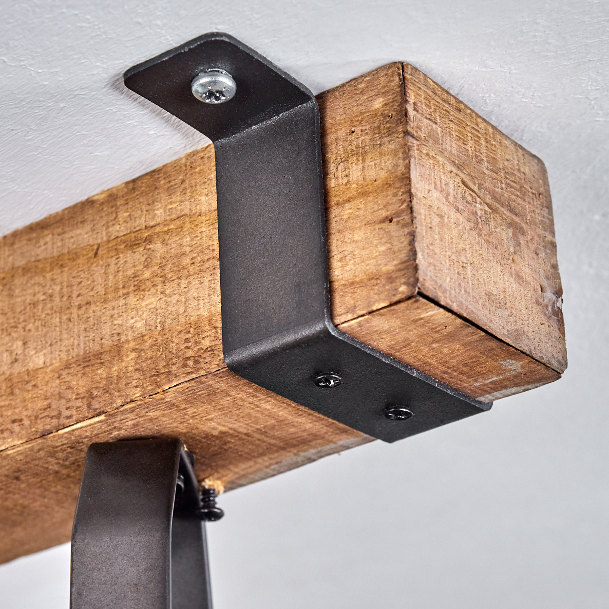 Holzbalken mit schwarzen Metallhalterungen an einer weißen Decke befestigt.