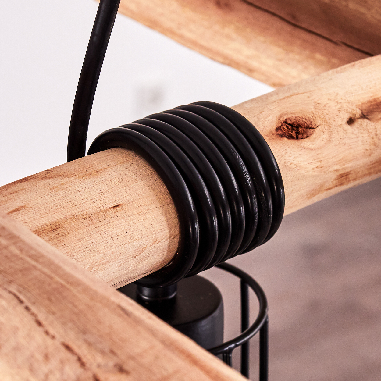 Schwarzes Kabel um Holzstab gewickelt, Nahaufnahme.