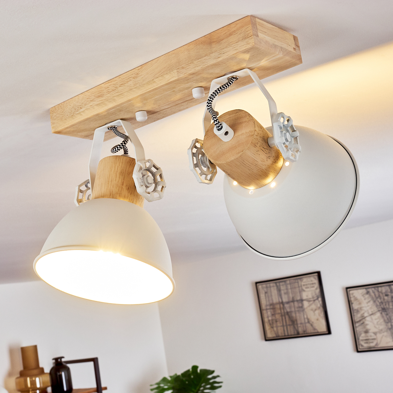 Zwei weiße Lampenschirme mit Holzdetails hängen von einer Holzleiste an der Decke.
