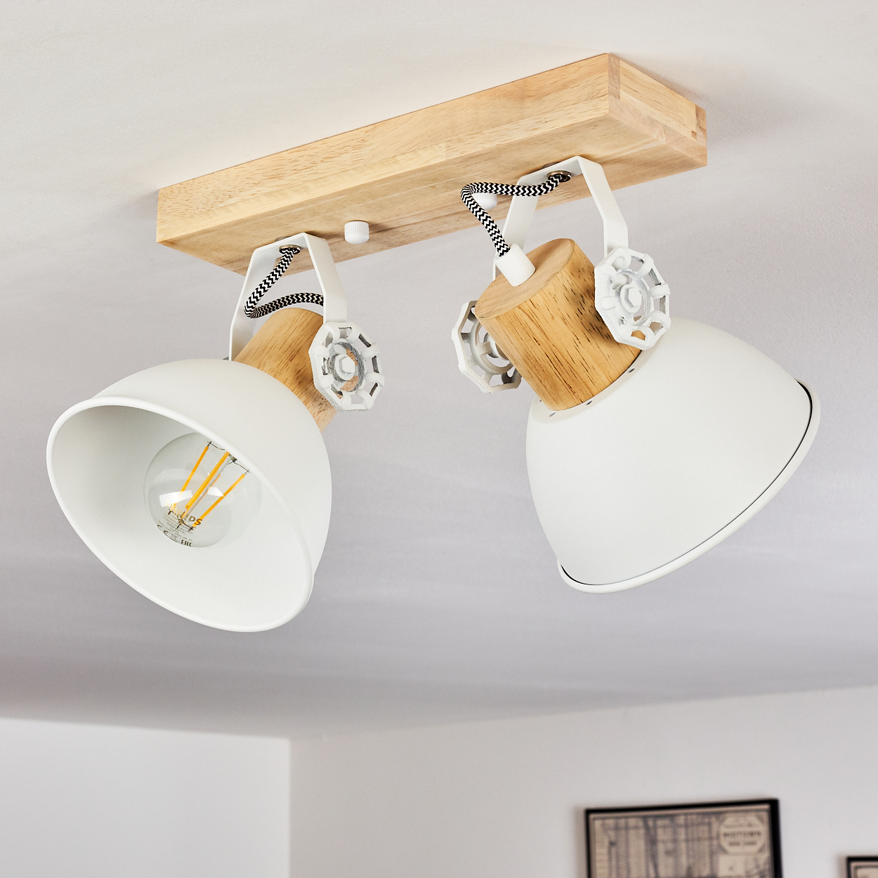 Zwei weiße Lampenschirme mit Holzdetails an einer Holzleiste an der Decke.
