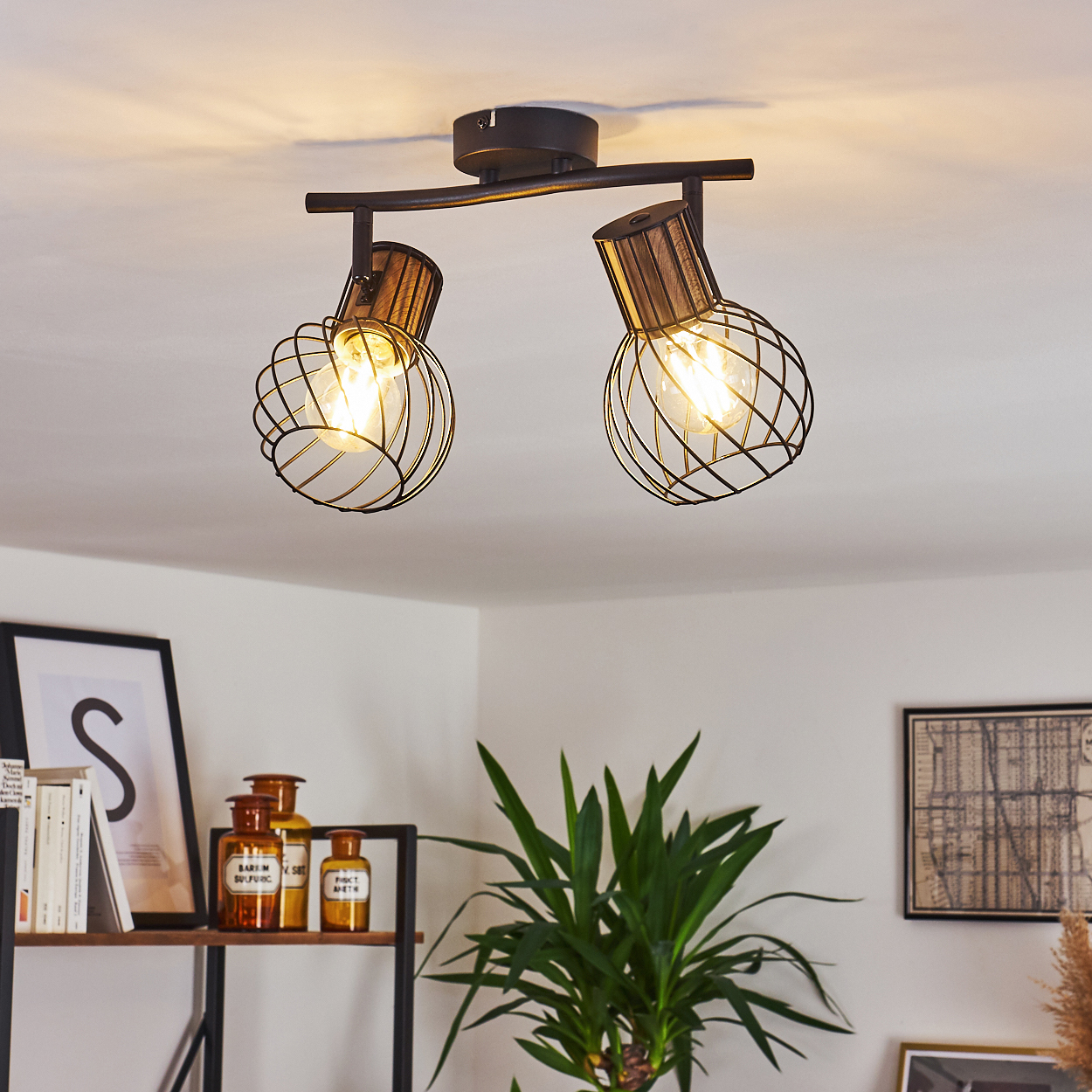 Ein dunkler Deckenstrahler mit zwei Lampen, Drahtkäfigen und Holzdetails.