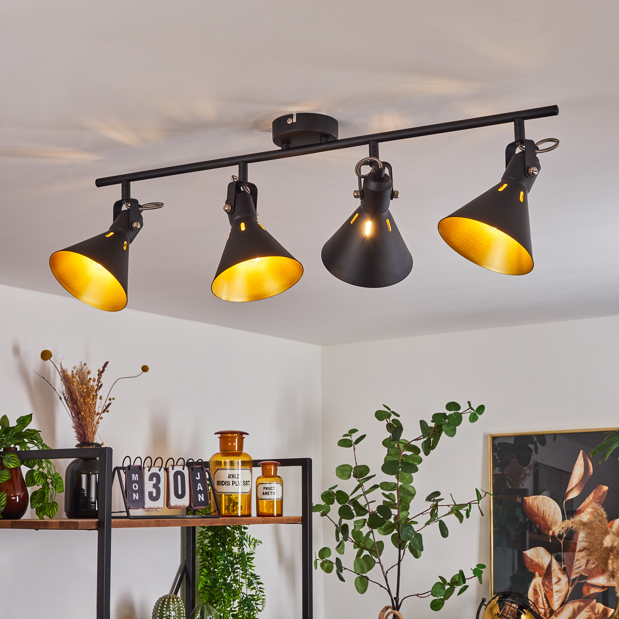 Schwarzer Deckenstrahler mit vier Lampen und goldenen Innenseiten.