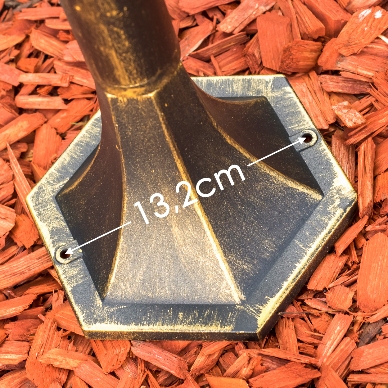 Ein goldener Sockel mit der Aufschrift 13,2 cm auf rotem Mulch.
