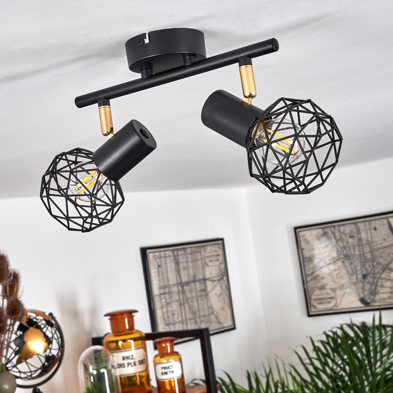 Schwarze Deckenleuchte mit zwei geometrischen Lampenschirmen und goldenen Akzenten.